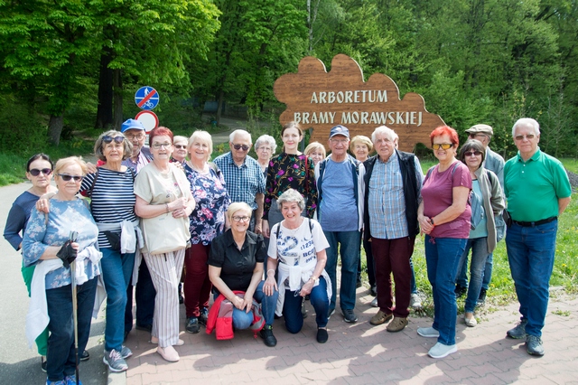 Seniorzy i dyrektor Elżbieta Skrzymowska przed wejściem do Arboretum Bramy Morawskiej.