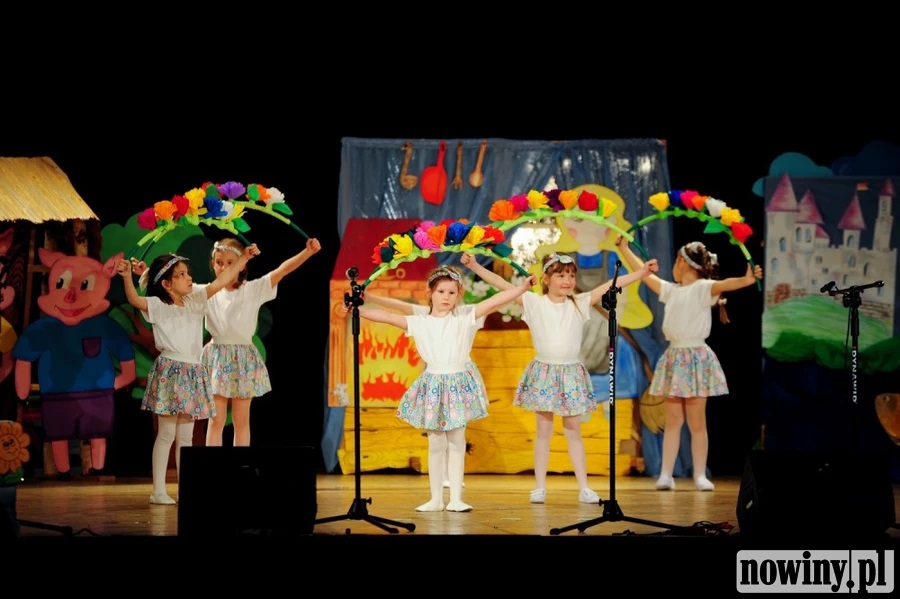 Dzieci z przedszkola nr 14 pod przewodnictwem pani dyrektor placówki Rity Wieczorek podczas tańca z dekoracją z barwnych kwiatów.